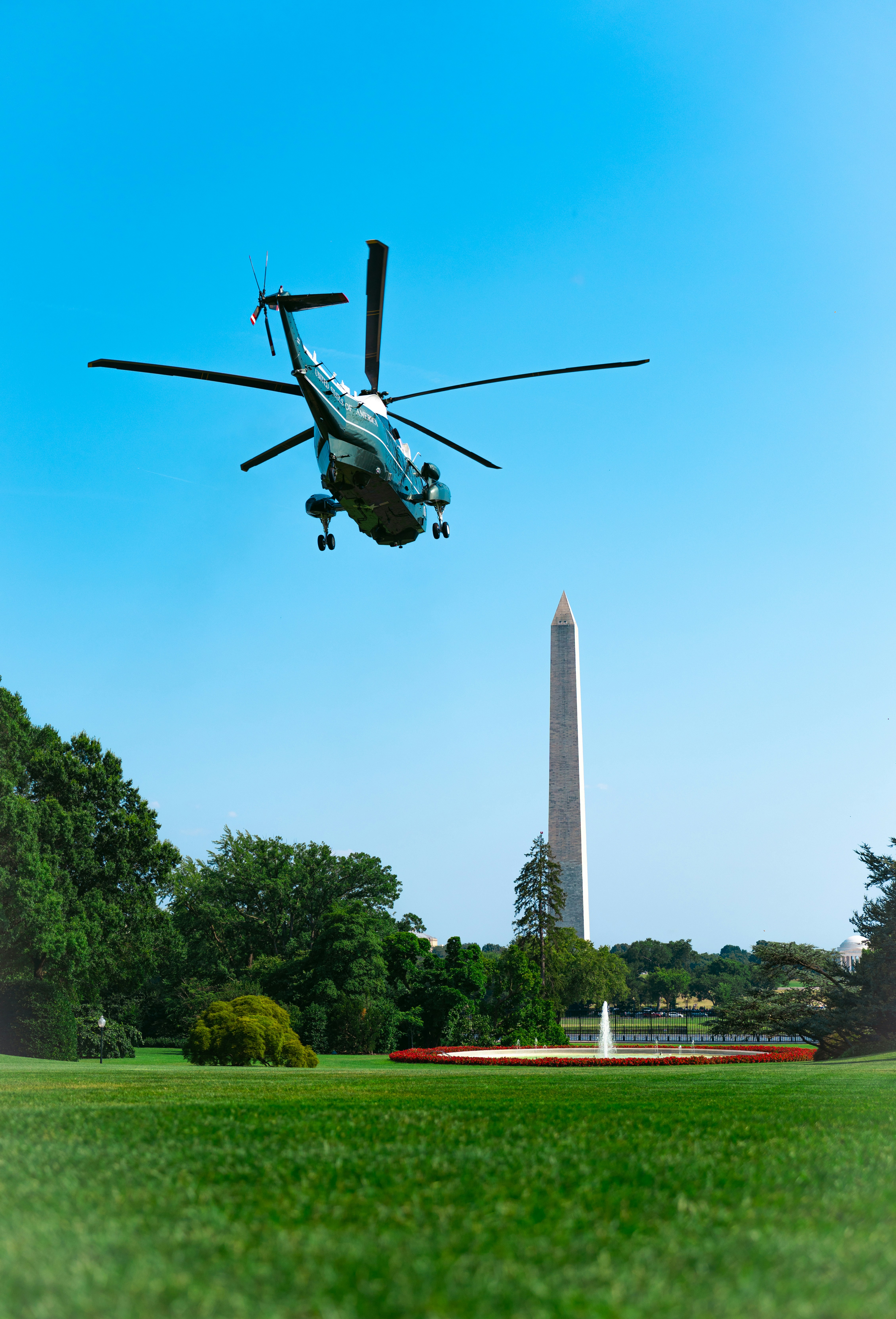 Marine One helicopter flying over the South Lawn of the White House with the Washington Monument in the background