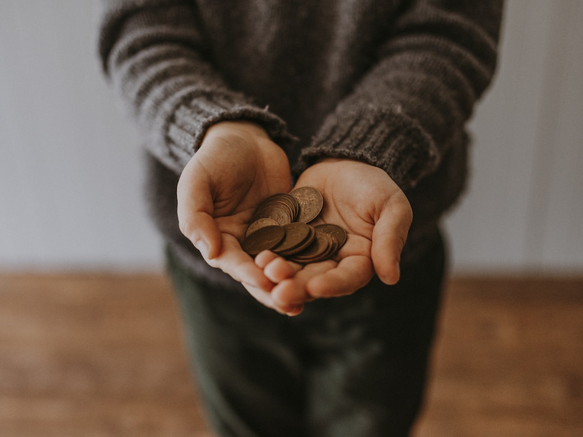 Hands holding coins above a table